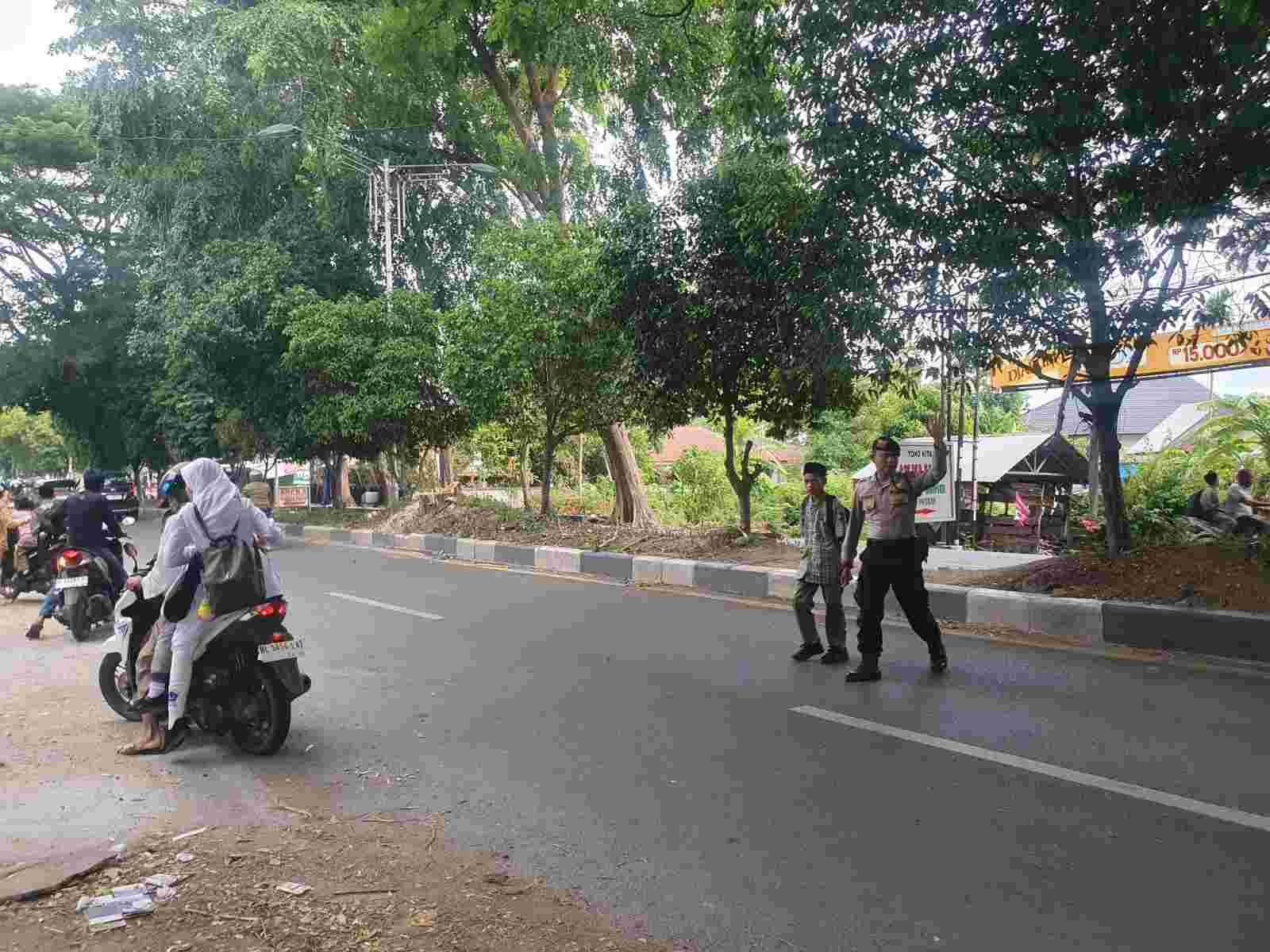 Polisi di Banda Aceh Jaga Keselamatan Anak Sekolah Saat Menyeberangi Jalan - Tribratanews Polresta Banda Aceh